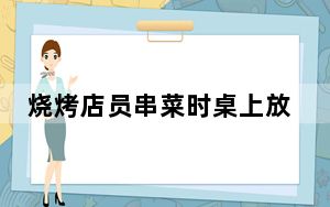 烧烤店员串菜时桌上放有两只狗 狗还咬了烤串签
